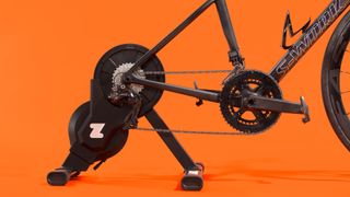 A Zwift Hub fitted to a bike on an orange background