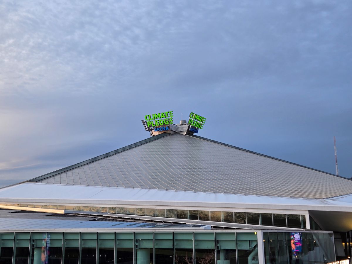 A neon sign on top of a building that reads "Climate Pledge Arena" at 2x zoom