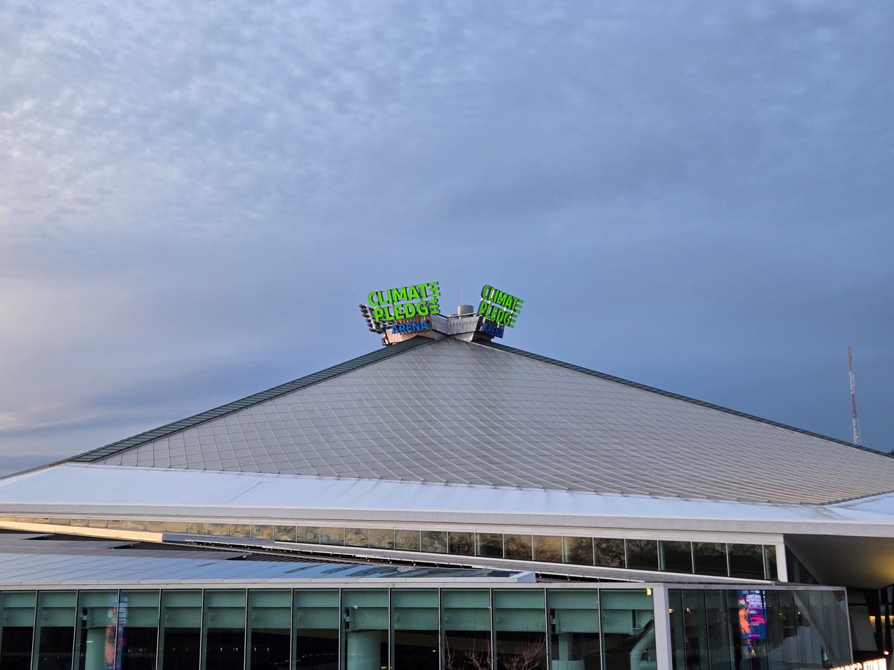 A neon sign on top of a building that reads "Climate Pledge Arena" at 2x zoom