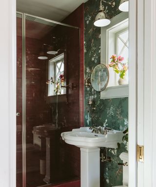 bathroom with dark pink tiles and floral green wallpaper