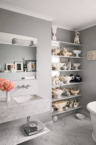 marble bathroom with large mirror and shelving