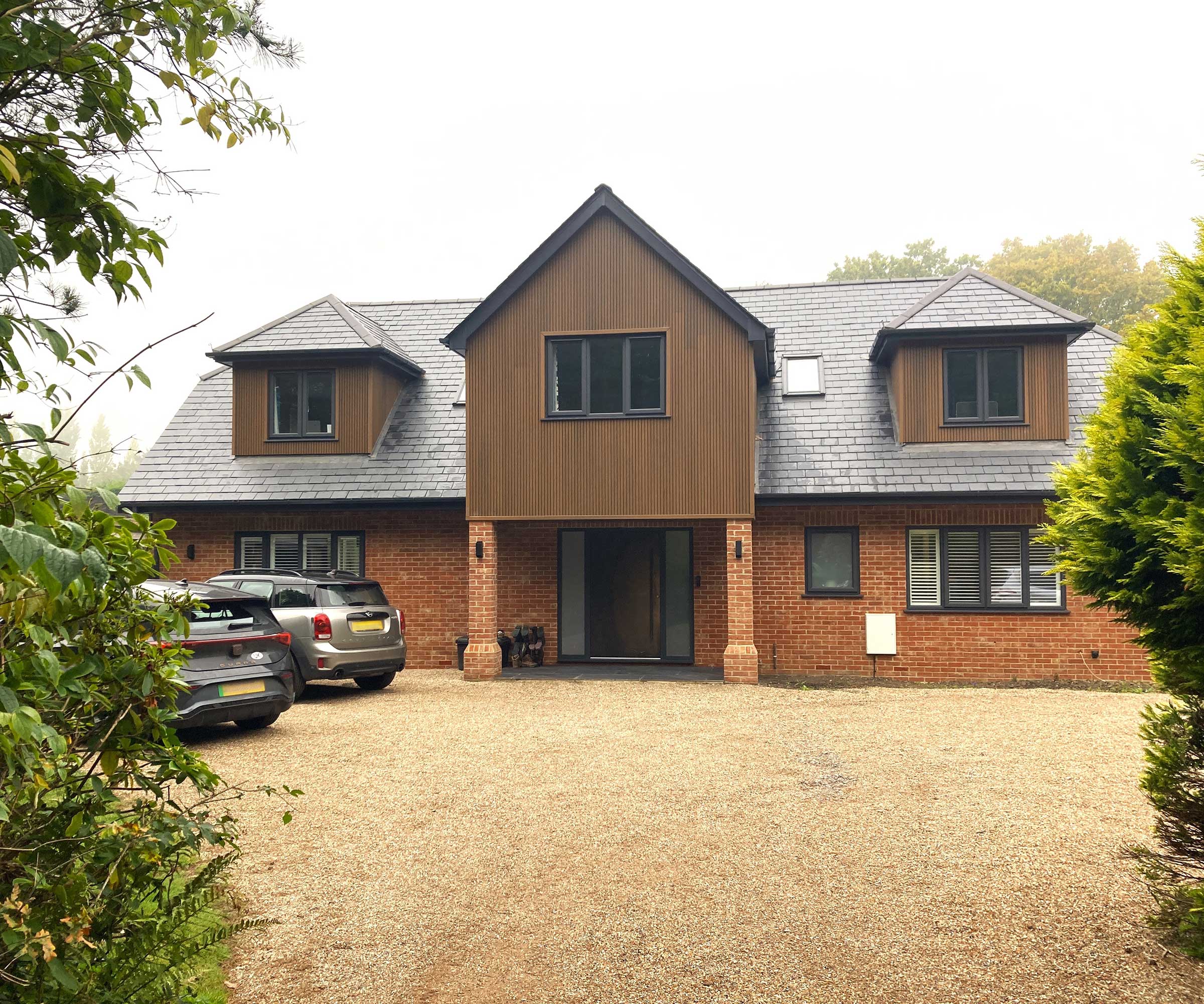 remodelled and extended 1960s house with a large gravel driveway