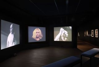 Videos of Inge Grognard hung in a dark room at MoMu Antwerp