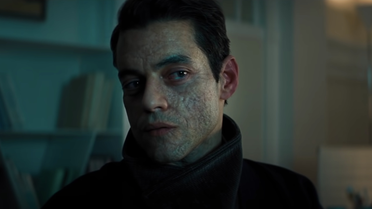 Rami Malek mira fríamente hacia la pantalla en No Time To Die.