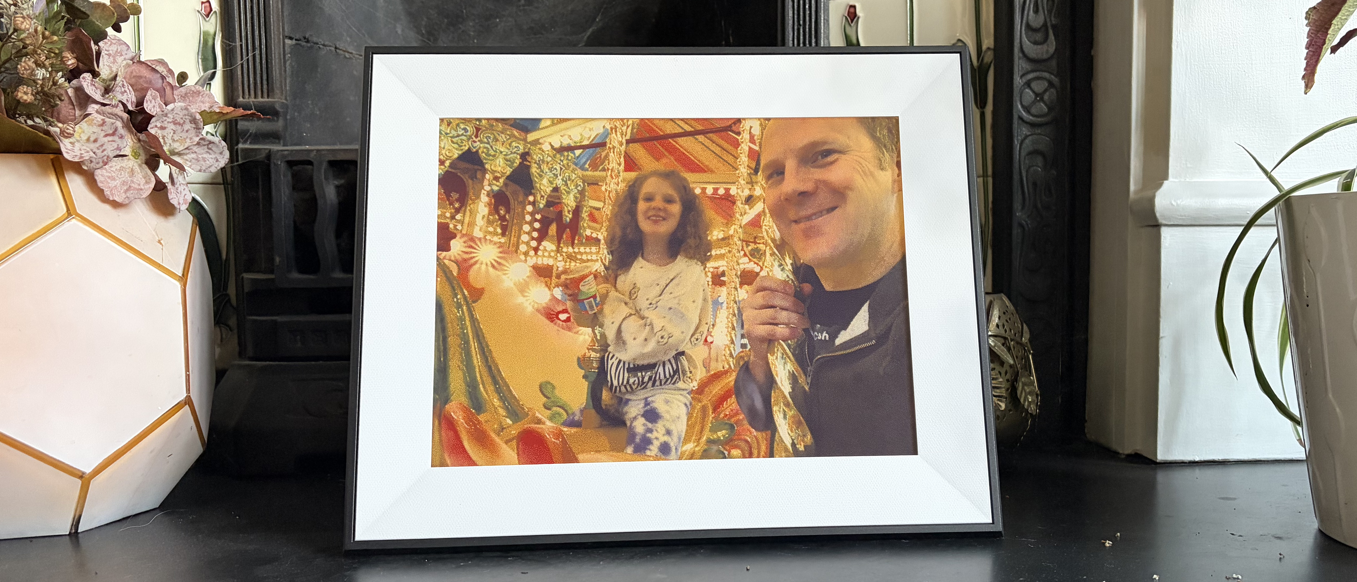 Aura Ink digital photo frame displaying a picture of a man and child at a fairground
