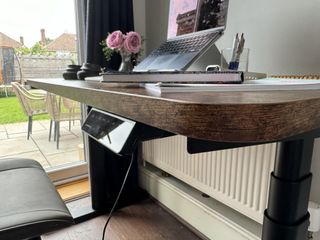 A brown wooden Maidesite TH2 Pro Plus desk in a bright home office