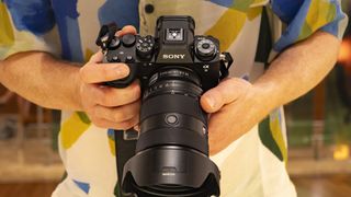 Sony A9 III dans la main avec objectif monté