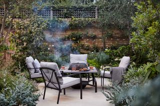 fire pit from dobbies in table with surrounding chairs on patio