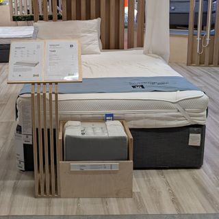 A mattress showroom with a wooden floor and multiple mattress on bed frames