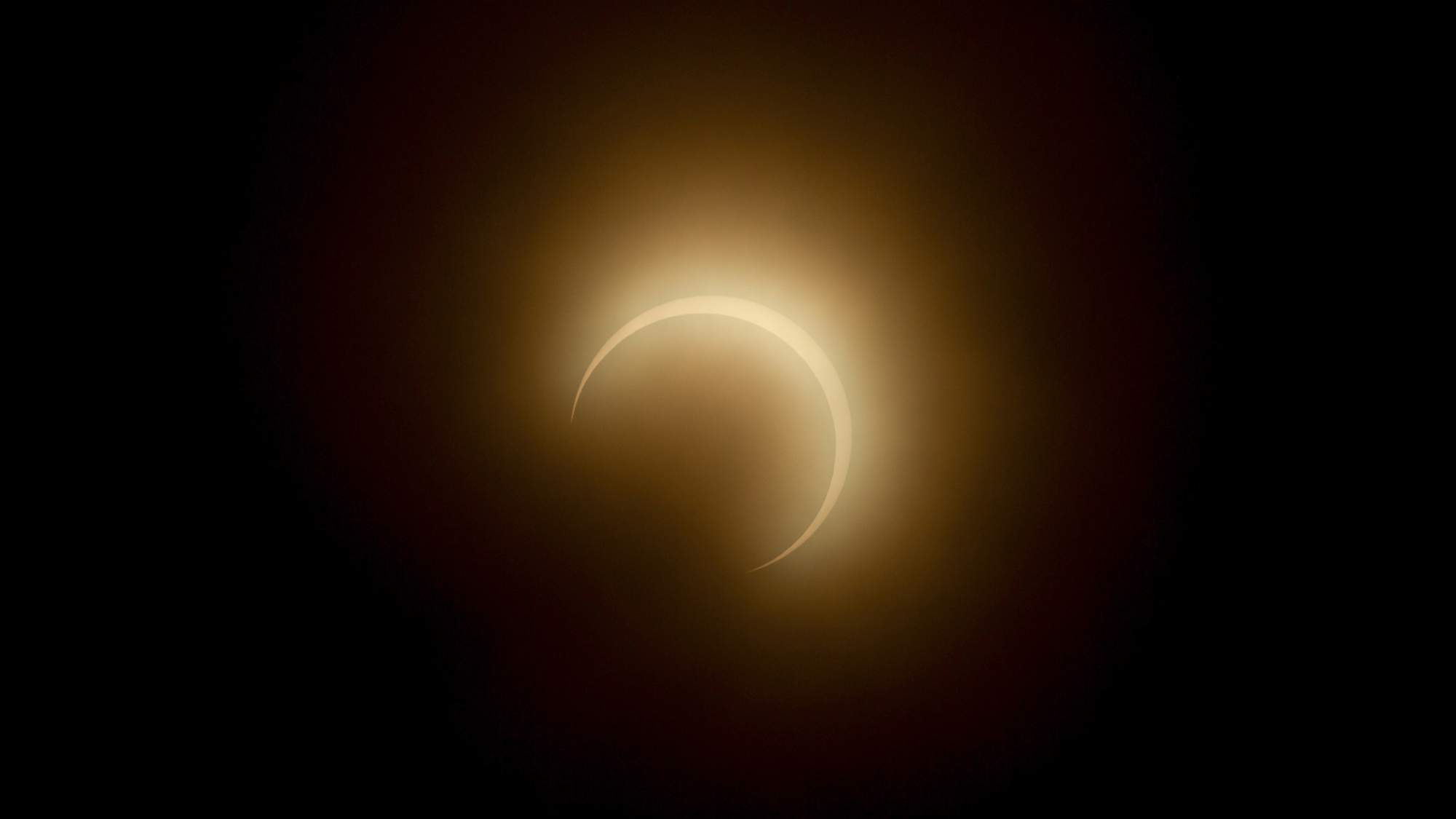 The sun's disk appears as a crescent during a partial solar eclipse in a black sky