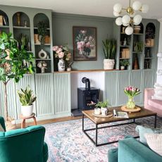 A living room with a built-in arched library in sage green made with IKEA BILLY bookcases