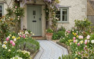 cottage garden with blue and cream patterned tiled path to front door