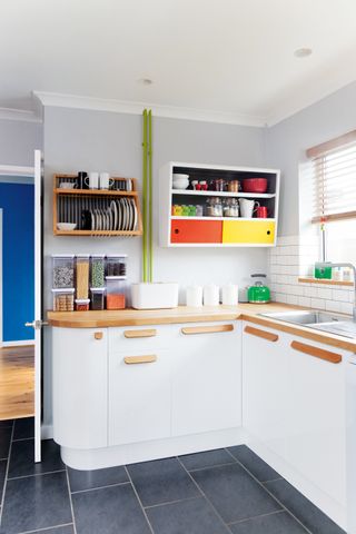White kitchen with updated wooden handles and brightly coloured painted touches
