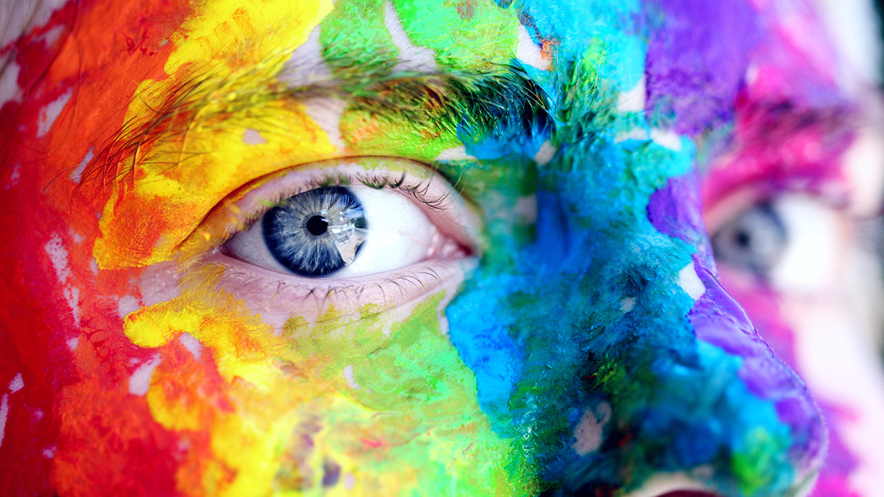 A woman bith blue eyes and colorful facepaint