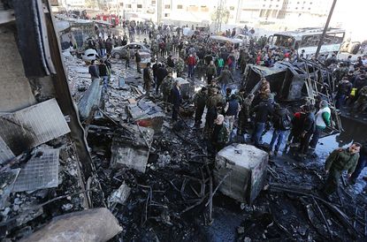 People gather at the site of suicide bombings near Damascus, Syria
