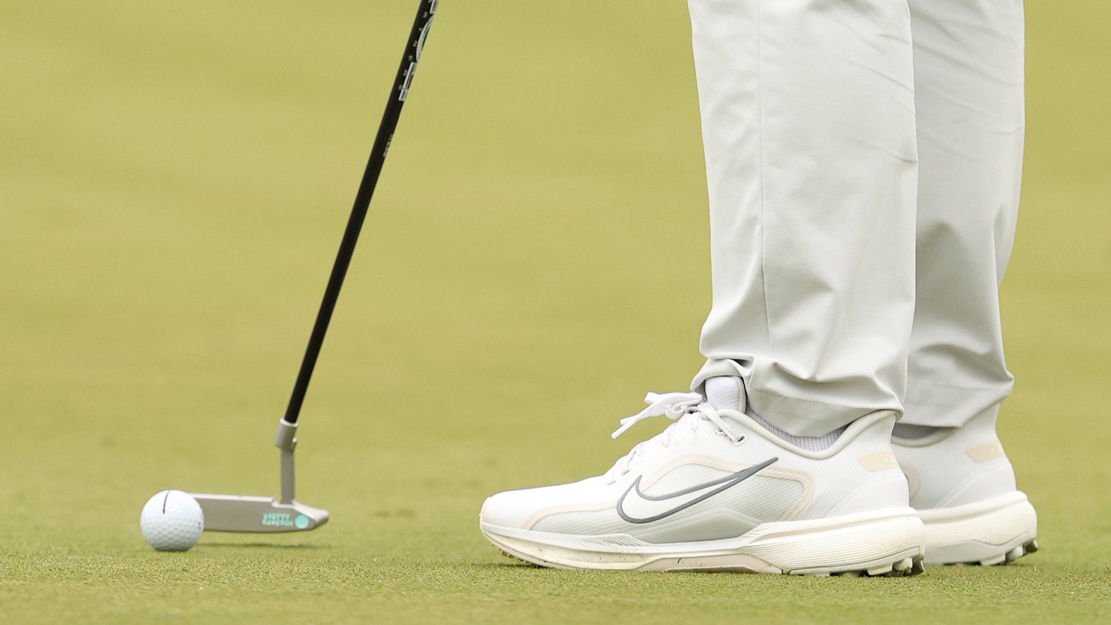 A close-up of Tom Kim's putter and shoes