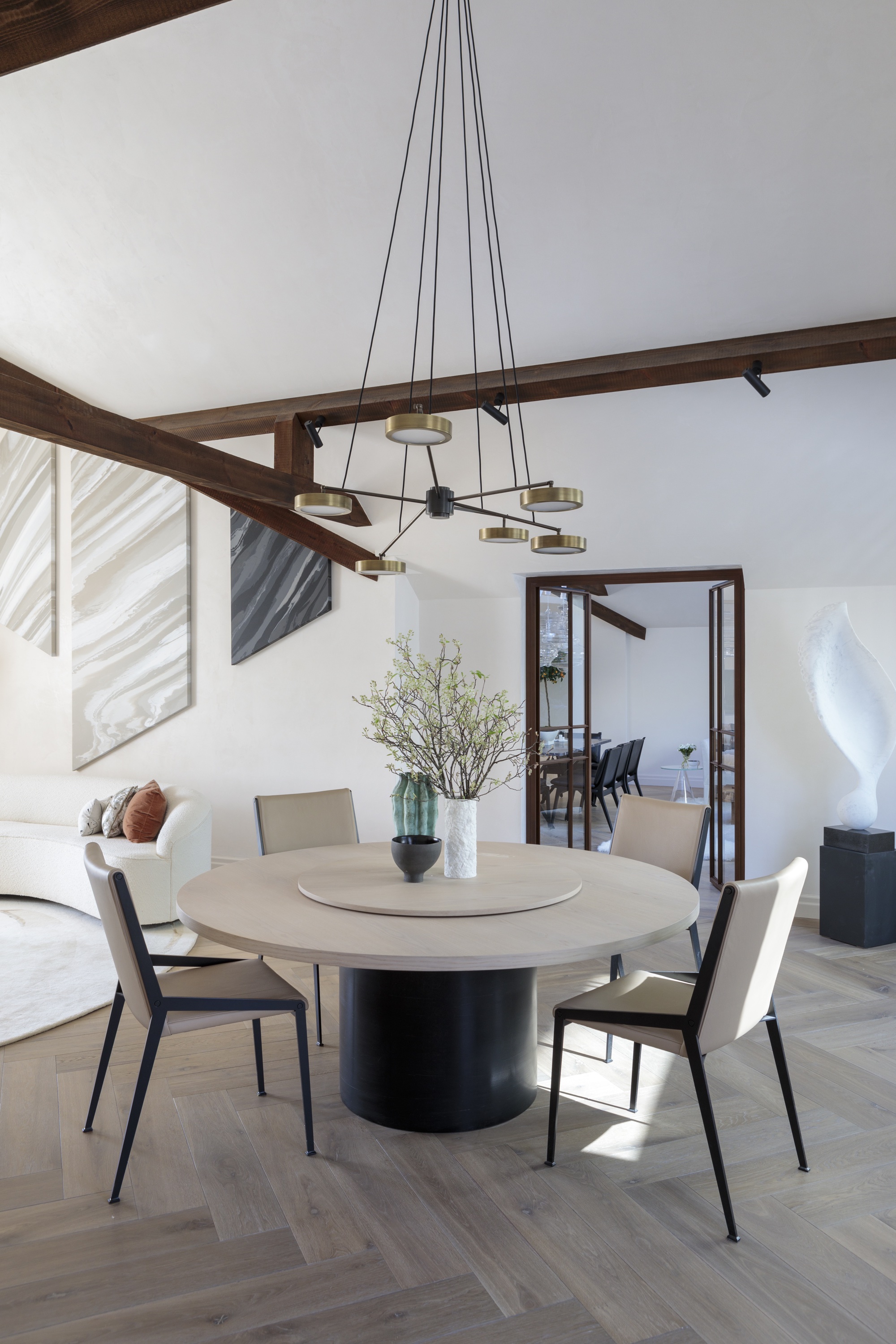 modern white dining room and round dining table in apartment by Kitesgrove