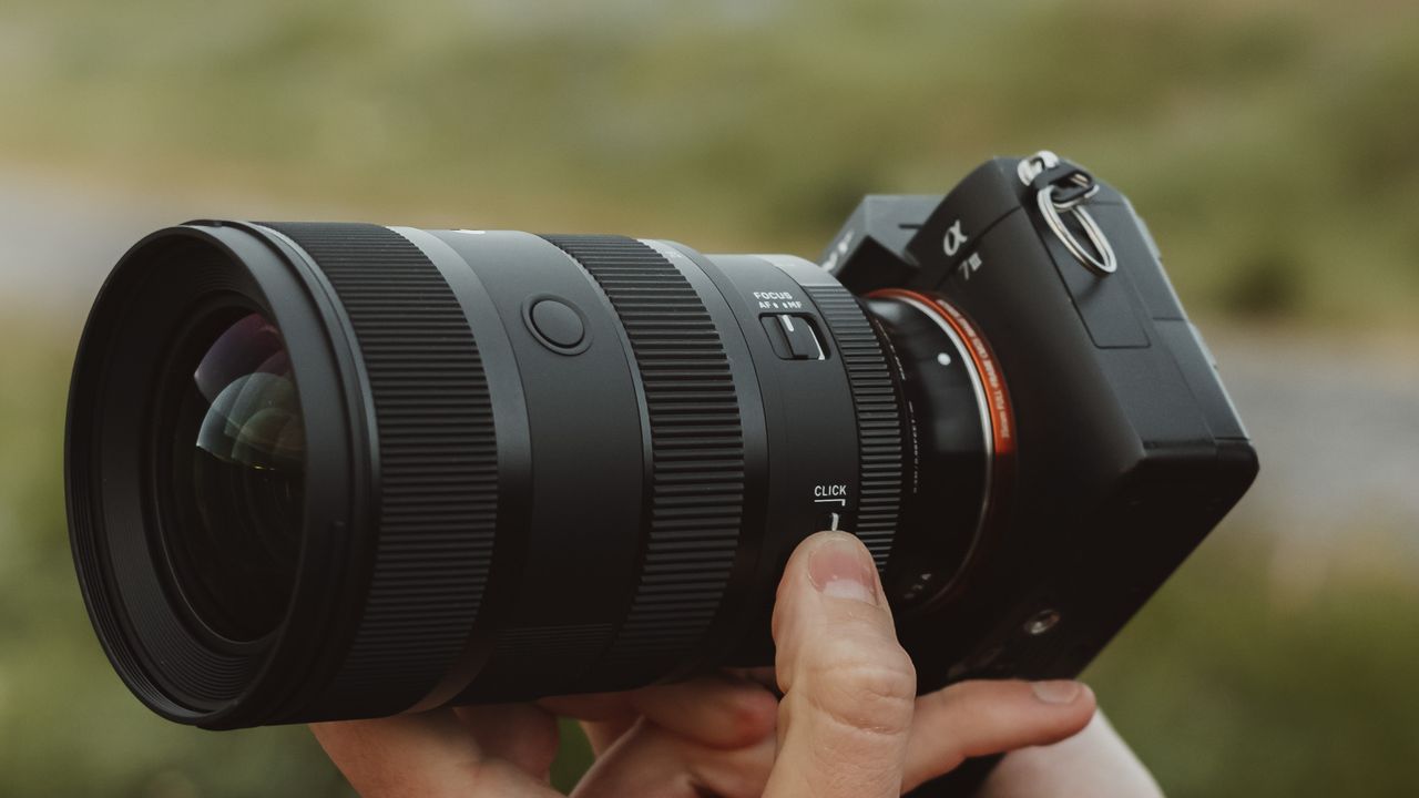 Sigma 28-45mm F1.8 lens mounted on a Sony camera being held by a photographer