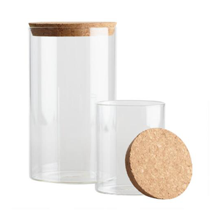 A pair of glass storage jars with cork lids