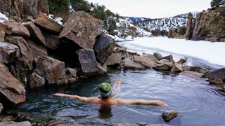A man soaks in Radium hot springs, Colorado