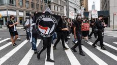 A protestor holds up an antifa flag during a protest in New York City