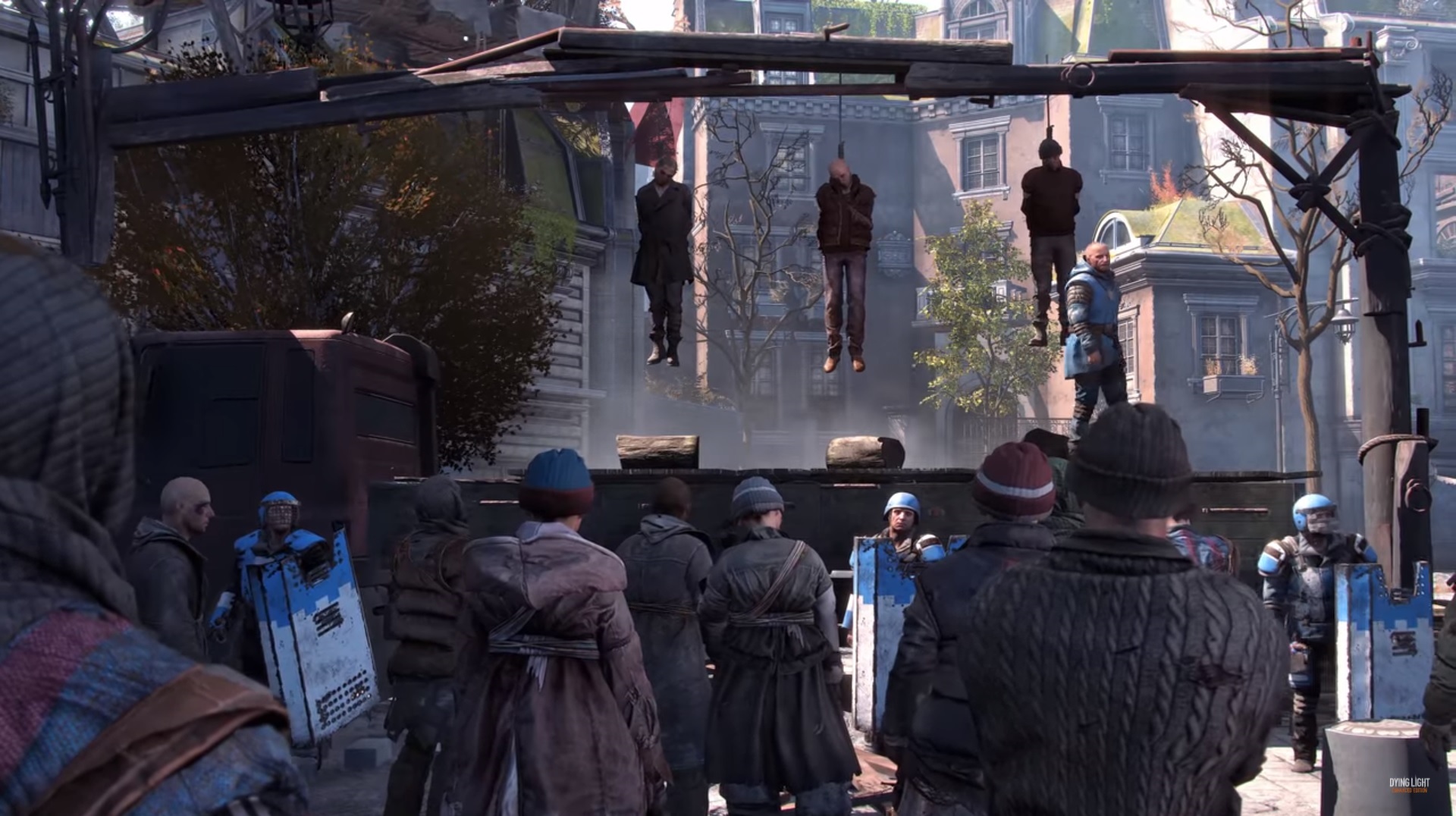 Dying Light 2 - Characters looking up at a gallows where three people and hanging.