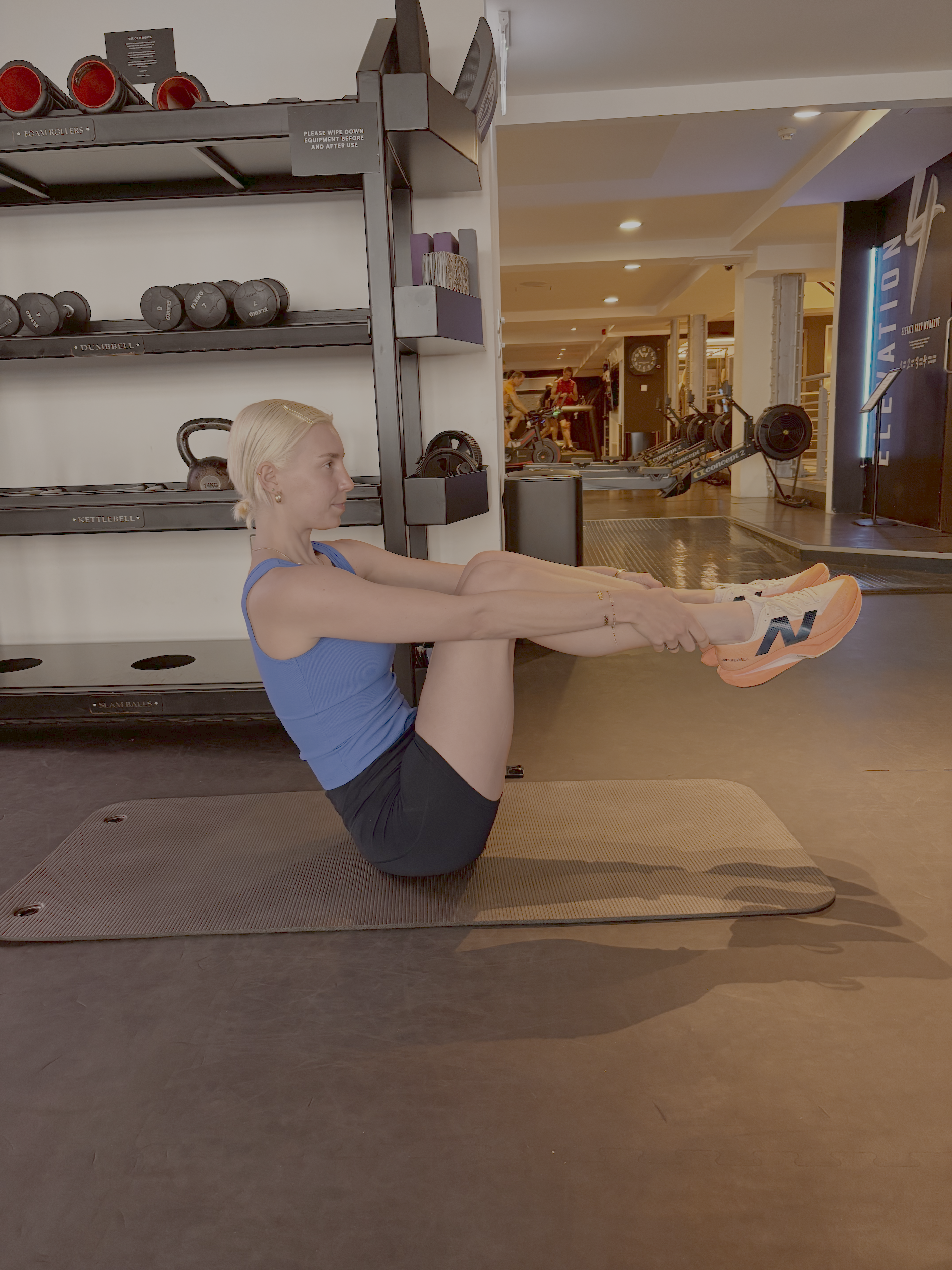 A woman practicing Pilates in a gym