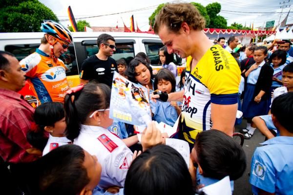 Many children gather around the riders