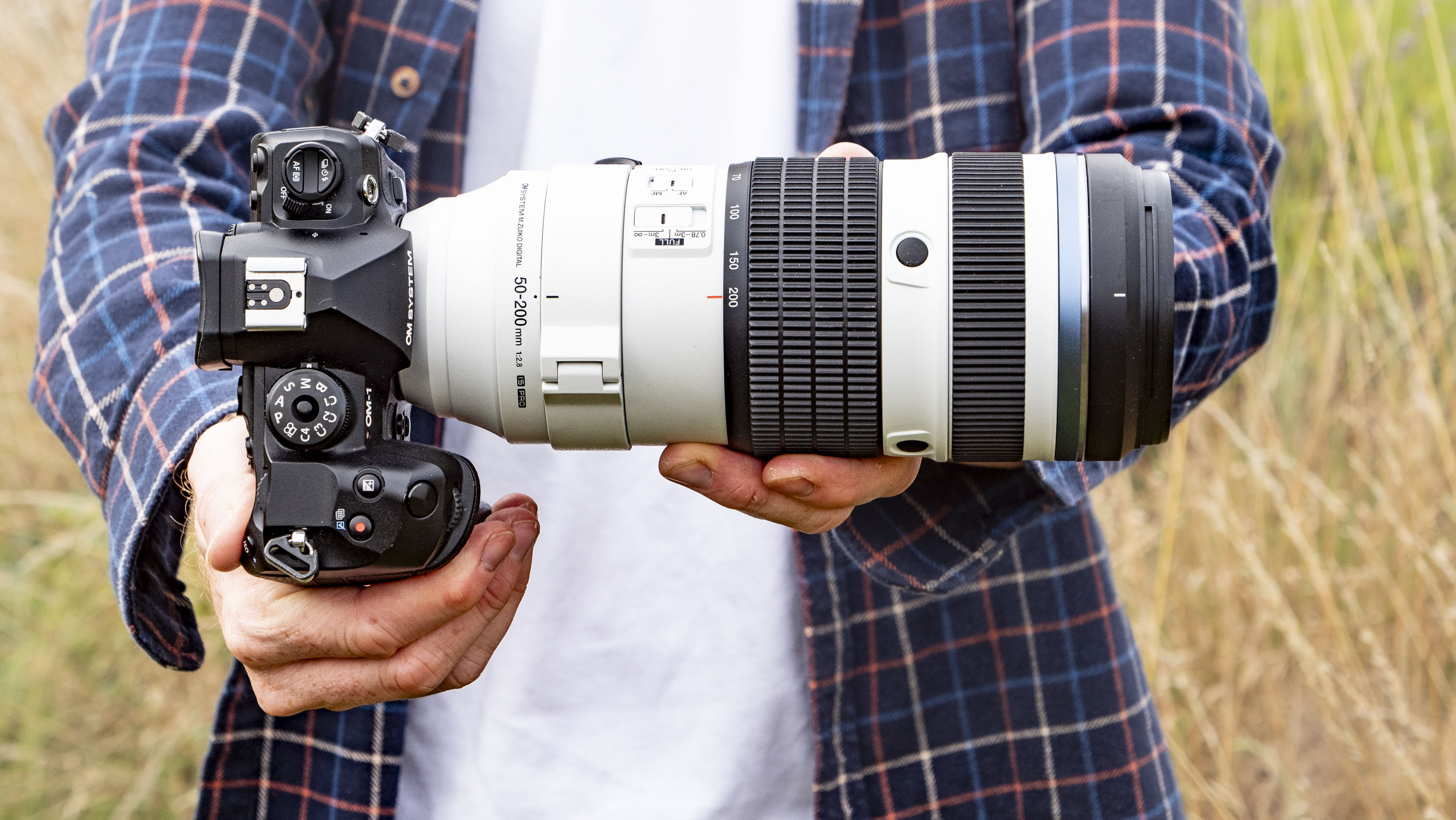 OM System M.Zuiko Digital ED 50-200mm F2.8 IS Pro lens in photographer's hands