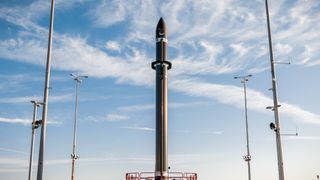 A Rocket Lab Electron rocket on its Virginia launch pad with a blue sky.