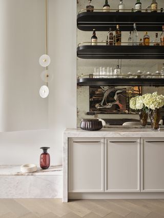 A home bar with shelves installed on a mirror