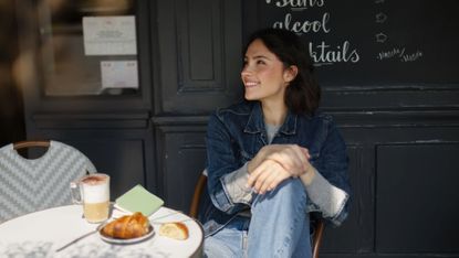 A young woman sitting at a Parisian caf&eacute; 