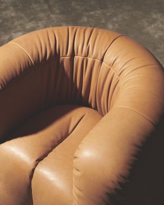 A close up of Philippe Malouin DS-707 armchair for De Sede upholstered in tan leather (Cuoio)