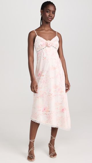 model wears lace trim pink and white slip dress with strappy heels