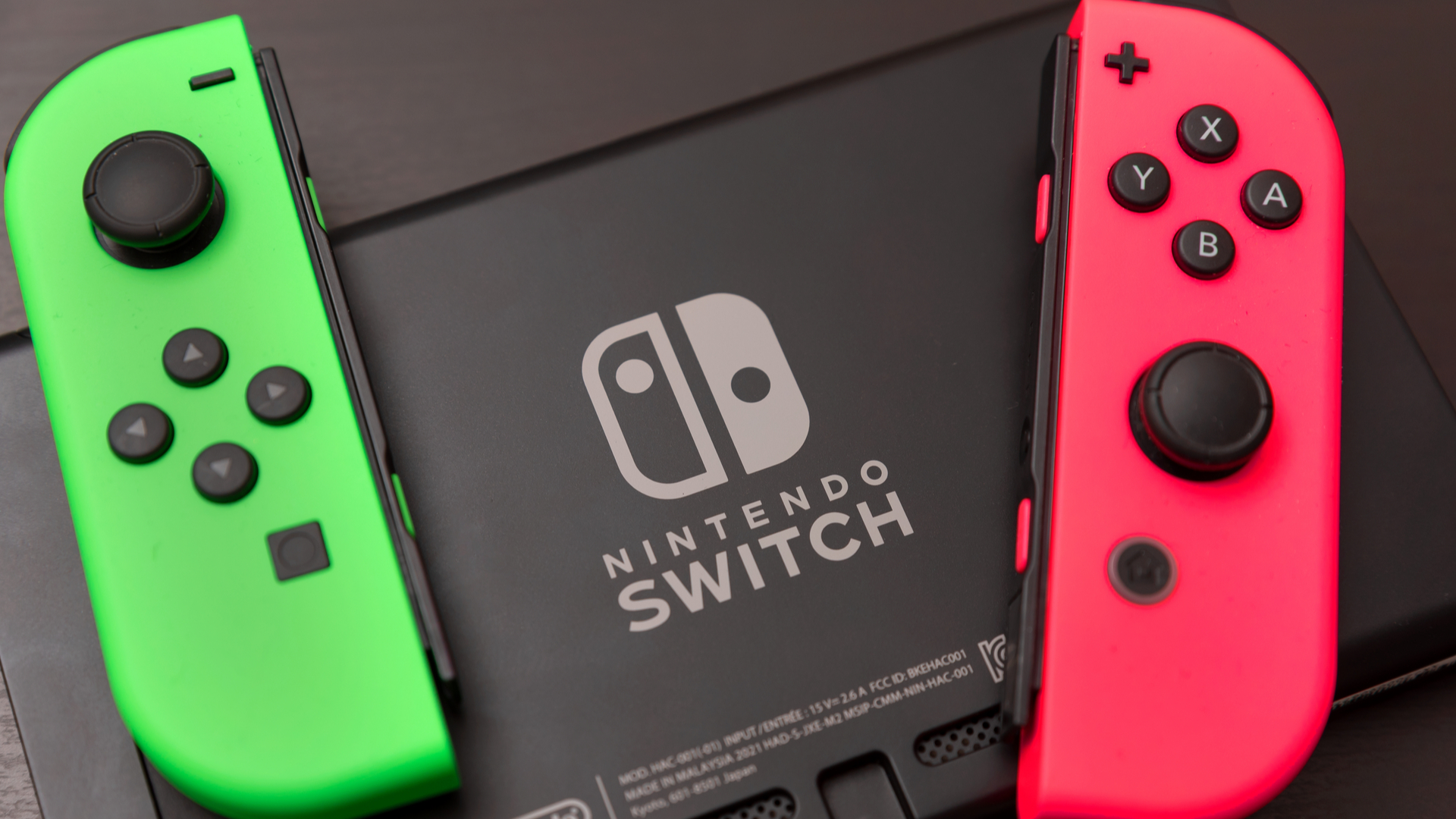 Зеленая и розовая радость -Кон сидит на задней панели Switch