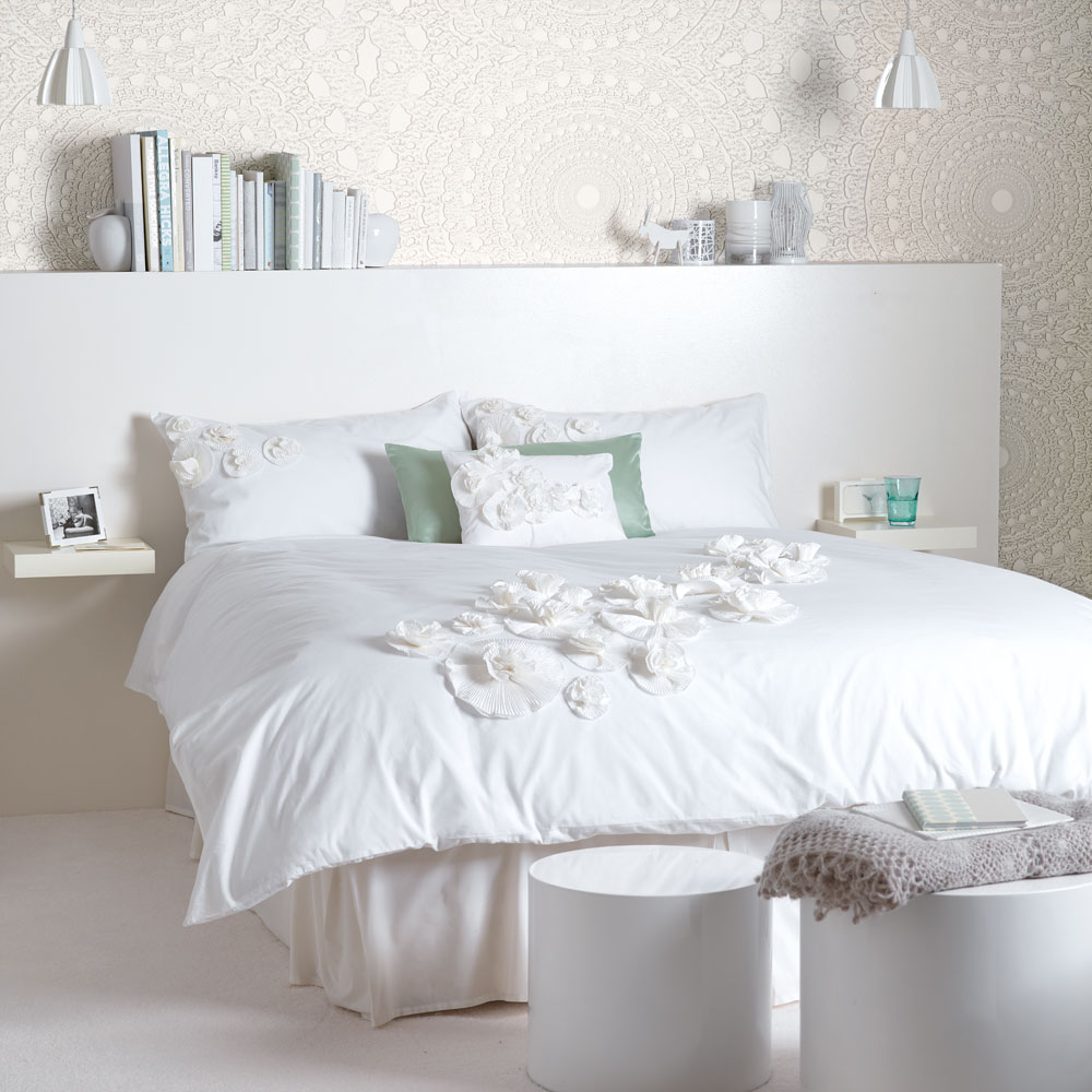 white bedroom with textured wallpaper and bedlinen