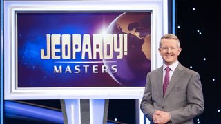 Ken Jennings in front of a monitor with the Jeopardy! Masters logo