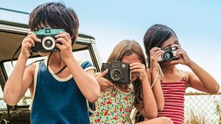 Three children holding cameras