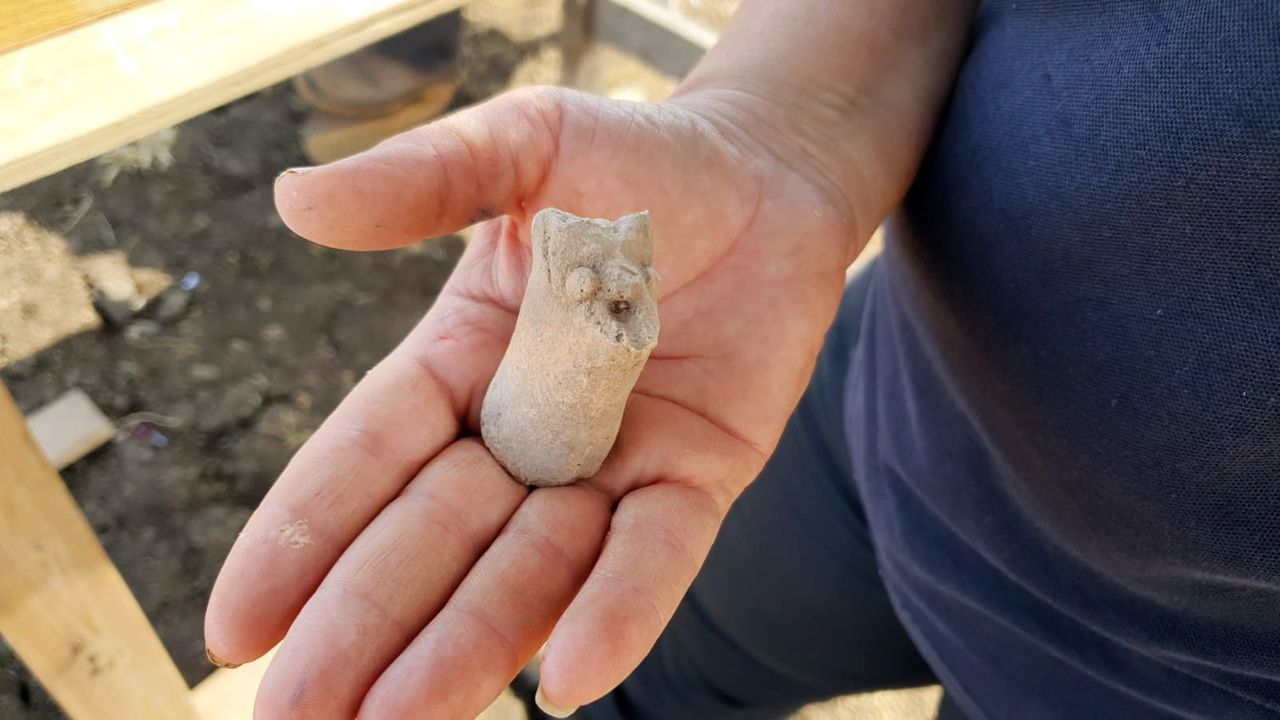Here we have a close up of a hand (open palm) holding a small pottery figurine found in the ruins of a farmstead in northern Israel which is thought to date from the Hasmonean period. It's about the size of a thick, adult thumb.