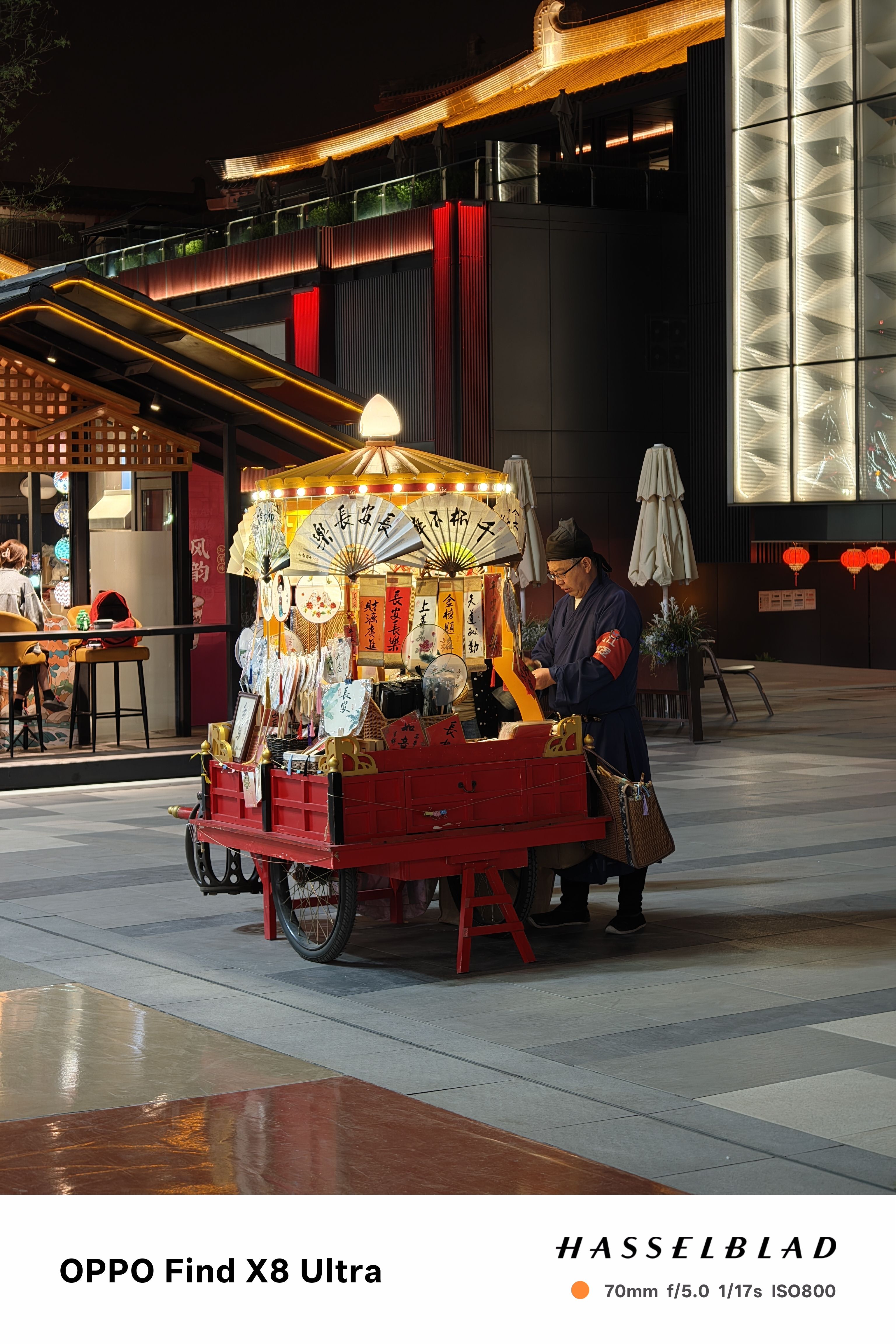 A stand lit up at night selling fans