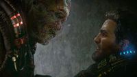 A man in futuristic armor faces a menacing, heavily scarred alien creature. The tense encounter is lit with glowing red and blue accents, conveying intensity.