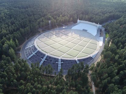 An aerial view of the National Open Air Stage surrounded by forestry. 