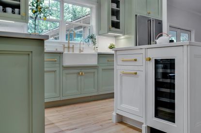 A kitchen with a mix of white and teal inset cabinets