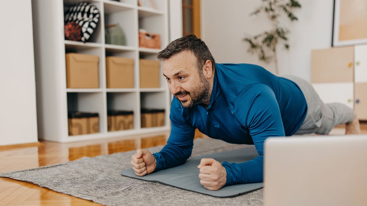 Man holds plank exercise at home