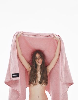 Nude model holding Kvadrat Raf Simons blanket