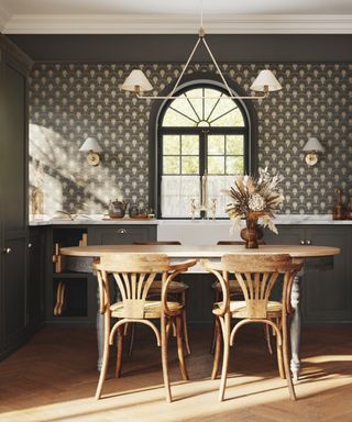 gray kitchen with oval dining table, gray wallpaper, wooden floor boards, white wall lights and matching pendant above table, floor to ceiling gray cabinets on left