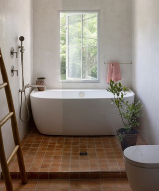 bathroom with terracotta tiles and freestanding bath