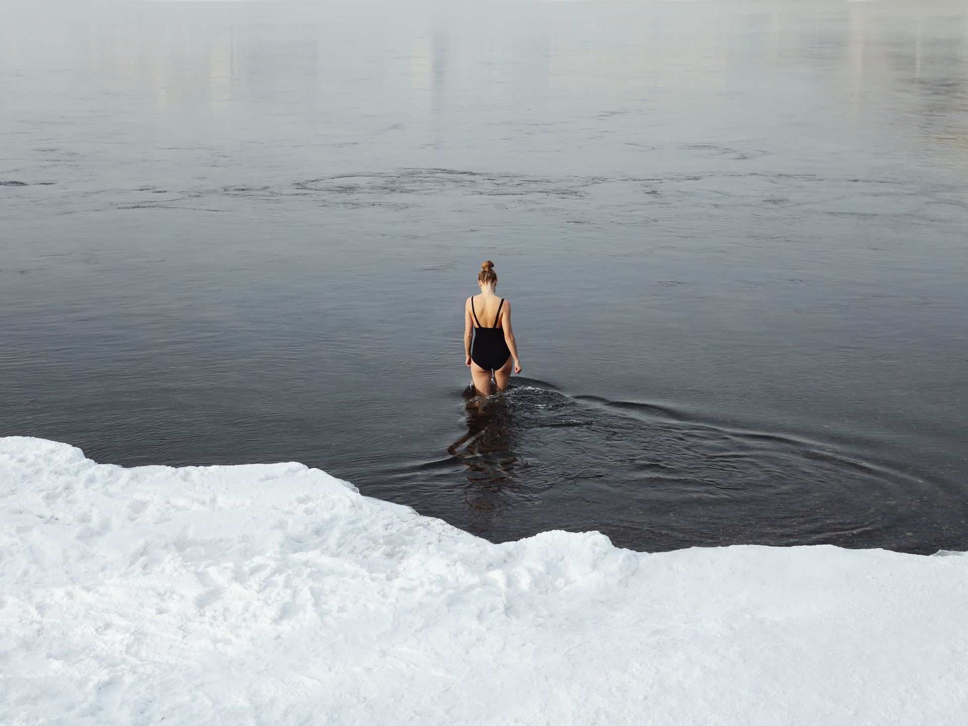Is cold water bad for you? A woman swimming in an ice lake