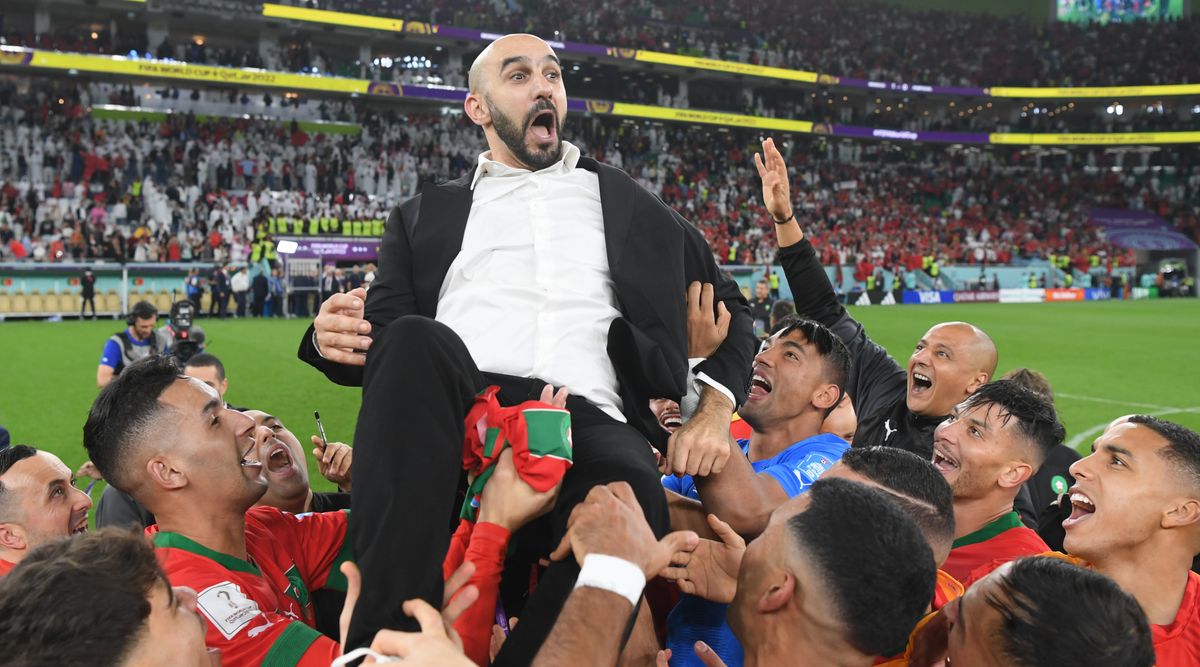 Morocco&#039;s players lift up head coach Walid Regragui in celebration after beating Portugal 1-0 in the quarter-finals of the FIFA World Cup 2022 in Qatar