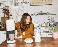 Drew Barrymore in a kitchen featuring her single-serve coffee machine